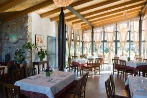 a dining room with tables and chairs and windows at Locanda Dei Cocomeri in Montalto Uffugo