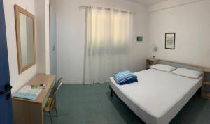 - une chambre avec un lit et un bureau avec un miroir dans l'établissement Brezza marina, à SantʼAndrea Apostolo dello Ionio