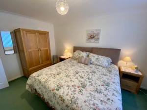 um quarto com uma cama com colcha floral em The Nook em Sidmouth