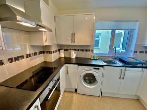 a kitchen with a washing machine and a sink at The Nook in Sidmouth