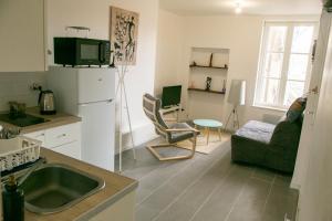 eine Küche mit einem Waschbecken und ein Wohnzimmer in der Unterkunft Relais du 21 in Saint-Germain-en-Laye