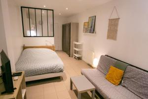 a living room with a bed and a couch at Relais du 21 in Saint-Germain-en-Laye