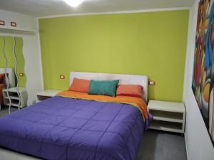 a bedroom with a purple bed and green walls at Costa dei trabocchi 2 in San Vito Chietino