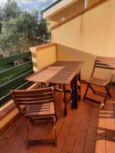 uma mesa de madeira e 2 cadeiras num pátio em Dolce Relax - Calabria em Catanzaro