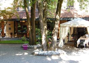 a group of trees with a table and an umbrella at Albergo Ristorante Sant'Eustorgio in Arcore