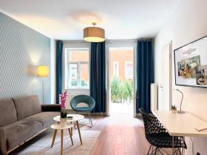 een woonkamer met een bank en een tafel bij Nurban Apartments City 2 in Neurenberg