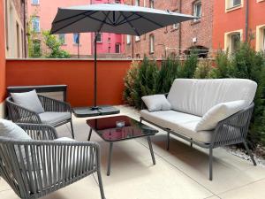a patio with two chairs and a table and an umbrella at Nurban Apartments City 2 in Nürnberg