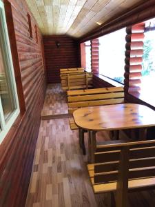 ein Esszimmer mit Holztischen und Bänken in der Unterkunft Pensiunea Cerbul in Lacul Roşu + 15 Fotos
