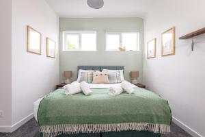 a bedroom with a large green bed with three windows at The Loft on the Lane - 2 Beds - Garden - 5 mins to harbour in Crail