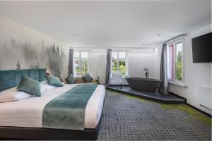 een slaapkamer met een groot bed en een bad bij Hotel Rheingerbe in Stein am Rhein