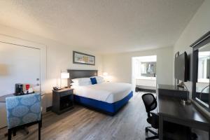 The Island Resort at Fort Walton Beach في شاطئ فورت والتون: غرفه فندقيه سرير وتلفزيون