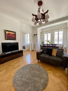 uma sala de estar com um sofá e uma televisão de ecrã plano em Deluxe Downtown Apartment with a Fabulous View em Budapeste