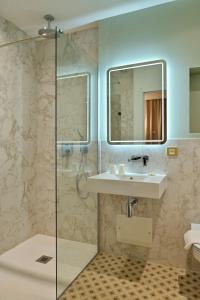 a bathroom with a sink and a shower at Hotel Des Roches in Sartène