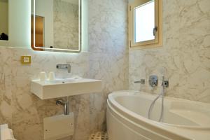 a bathroom with a sink and a bath tub at Hotel Des Roches in Sartène +43 photos