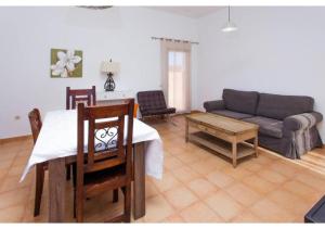 a living room with a table and a couch at Anahi Homes Corralejo - Villa Dracaena 2 in La Oliva