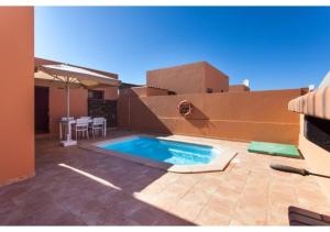 a swimming pool in the backyard of a house at Anahi Homes Corralejo - Villa Dracaena 2 in La Oliva