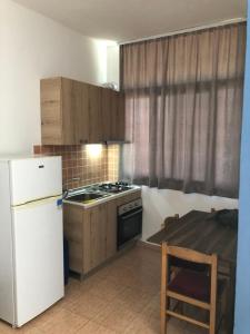 a kitchen with a stove and a refrigerator and a table at Sunnyside Apartments in Hamallë
