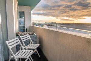 two white chairs sitting on a balcony overlooking the beach at The Midland in Morecambe