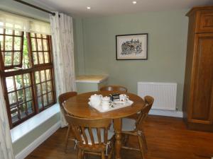a dining room with a wooden table and chairs at Centre Chipping Campden - 3 Bedroom Cottage for 5 in Chipping Campden