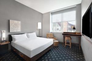 デンバーにあるThe Slate Hotel Denver Downtown, Tapestry by Hiltonのベッドルーム1室(白いベッド1台、デスク、窓付) +37枚の写真