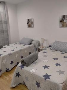 um quarto com duas camas e um cobertor com estrelas em Casilla em Sarria