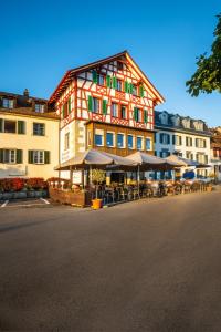 um grande edifício com mesas e cadeiras em frente em Hotel Rheingerbe em Stein am Rhein