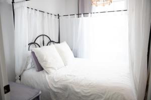 een slaapkamer met een wit bed en een raam bij Modern Apt Near Downtown Burlington Ideal for long stays - U2 - The Blair in Burlington