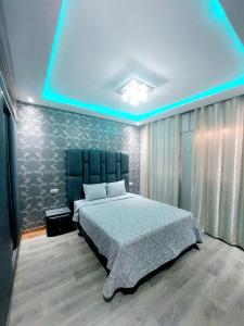 sypialnia z dużym łóżkiem z niebieskim oświetleniem w obiekcie Appartement Agadir w mieście Agadir