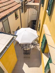 un parasol installé sur une terrasse dans une ruelle dans l'établissement La Casetta di Emma, à Villa Faraldi