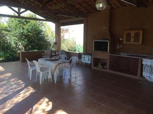 a patio with a table and chairs and a kitchen at Chalé Aconchegante in Maria da Fé