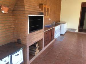 a kitchen with a brick wall at Chalé Aconchegante in Maria da Fé
