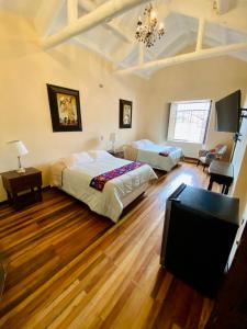 a bedroom with two beds and a flat screen tv at Cusco Hotel Boutique in Cusco
