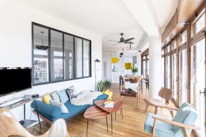 a living room with a blue couch and a tv at THE BUILDING - Appartement d'architecte avec vue Notre Dame de la Garde in Marseille