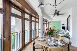 a dining room with a table and chairs and large windows at THE BUILDING - Appartement d'architecte avec vue Notre Dame de la Garde in Marseille