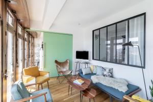 a living room with a blue couch and chairs at THE BUILDING - Appartement d'architecte avec vue Notre Dame de la Garde in Marseille