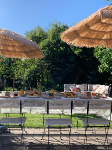 een tafel met eten en paraplu's bij Bed & Breakfast Neeltje Soet in Mierlo