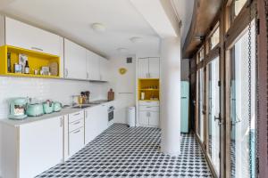 a kitchen with white cabinets and a black and white tiled floor at THE BUILDING - Appartement d'architecte avec vue Notre Dame de la Garde in Marseille