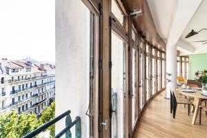 an apartment with a balcony with a table and chairs at THE BUILDING - Appartement d'architecte avec vue Notre Dame de la Garde in Marseille