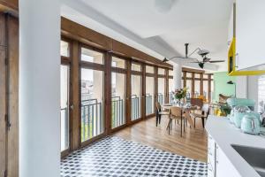 a kitchen with large windows and a dining room with a table at THE BUILDING - Appartement d'architecte avec vue Notre Dame de la Garde in Marseille