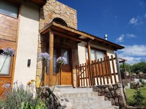a stone house with a wooden door and stairs at Casa El Drago in La Cumbre