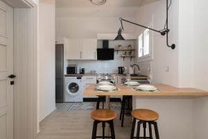 a kitchen with a table and stools in a room at Camara Luxury Apartments (Standard Apartment) in Pylos