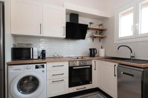 a kitchen with a washing machine and a microwave at Camara Luxury Apartments (Standard Apartment) in Pylos +3 photos