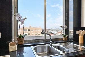 a kitchen counter with a sink and a window at Leça Front Beach Luxury Penthouse in Leça da Palmeira +54 photos