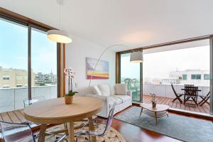 - un salon avec une table et un canapé dans l'établissement Leça Front Beach Luxury Penthouse, à Leça da Palmeira