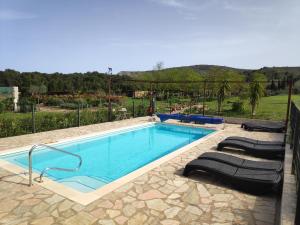 a swimming pool with two loungers in front at Mas Del Llop Blanc - Dog friendly Hostal Rural - B&B in Sobrestany