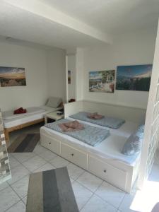 two beds in a white room with two beds at Hotel Garni Steinbacher Tal in Heidelberg