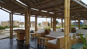 a pavilion with couches and tables on a patio at Solé Paracas in Paracas