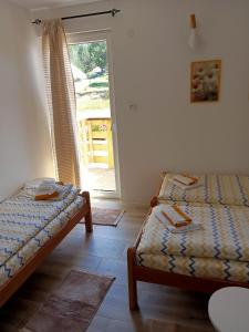 a room with two beds and a window with a door at Vila Danida in Žabljak