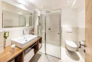 a bathroom with a shower and a sink and a toilet at Hotel Sella***s in Selva di Val Gardena