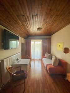 een slaapkamer met een bed, een tafel en een televisie bij Hotel Seestuben in Villach